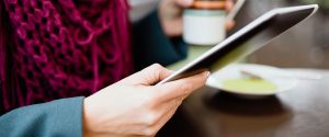 woman using mobile tablet at a coffe shop