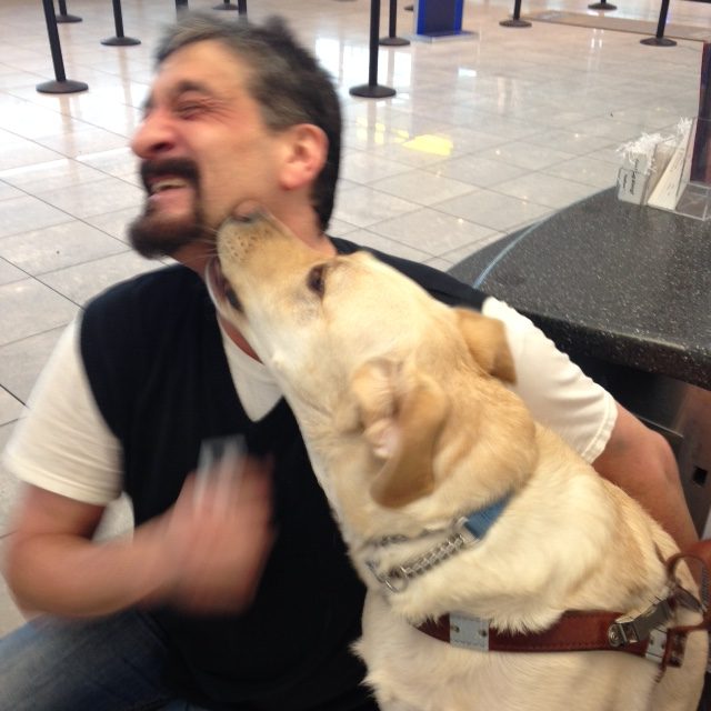 Albert Rizzi receives a big kiss from his guide dog, Vaughn