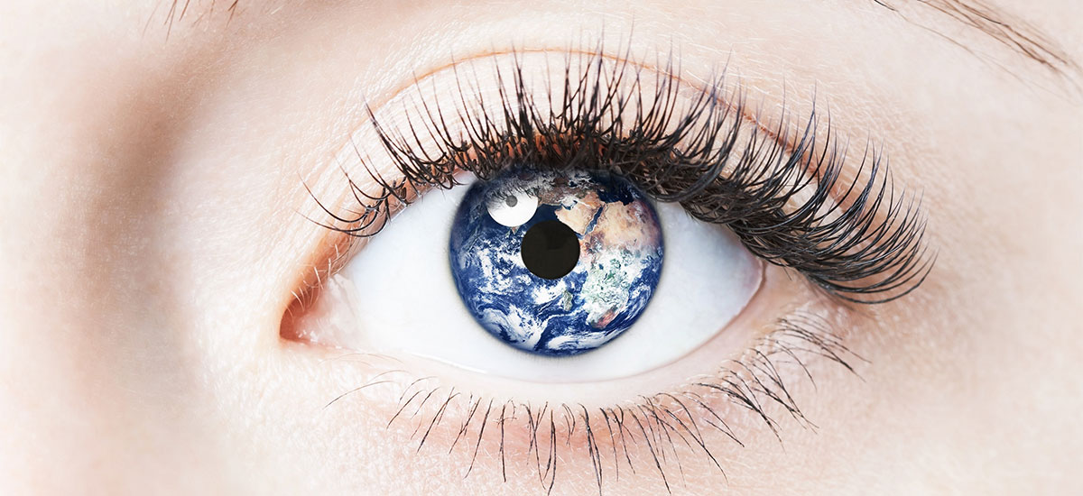 Close up of women's eye with the earth superimposed on the iris.