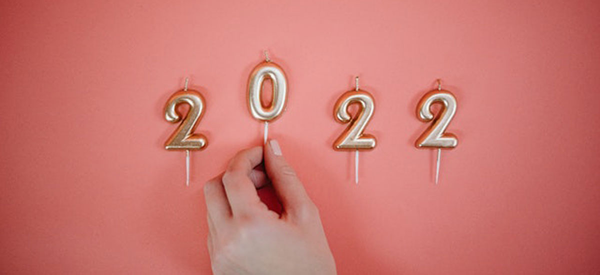 A person placing individual candles to spell out “2022”.