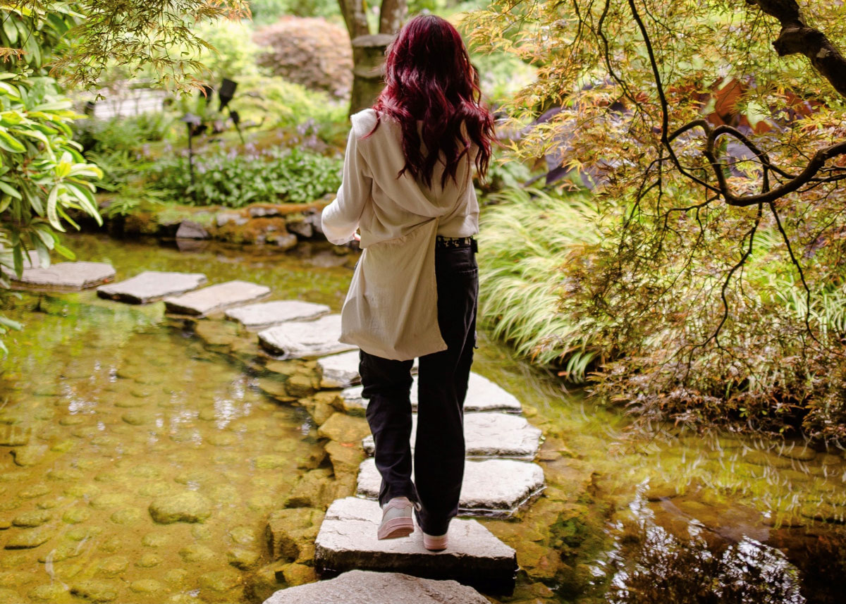 a woman walking on stepping stones.